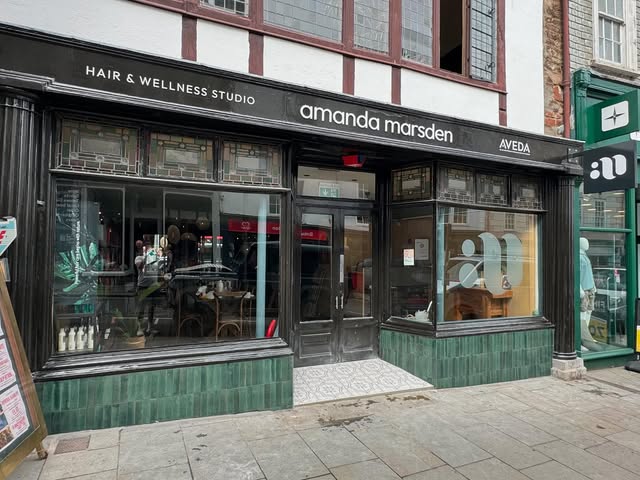 Green glazed tiles and patterned entrance on a high street shopfront