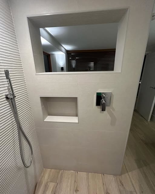 Walk-in shower with recessed niche and textured feature wall